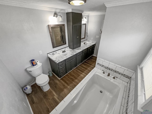 bathroom with crown molding, hardwood / wood-style flooring, a bathing tub, vanity, and toilet