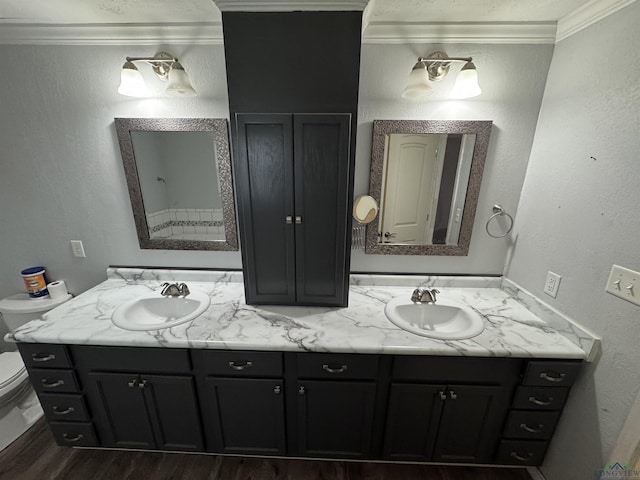 bathroom featuring hardwood / wood-style flooring, crown molding, vanity, and toilet