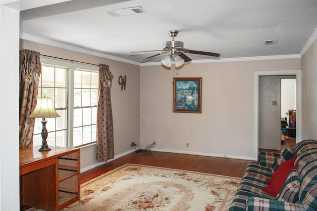 living area with wood-type flooring, ornamental molding, and ceiling fan