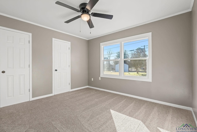 unfurnished bedroom with ceiling fan, carpet flooring, crown molding, and two closets