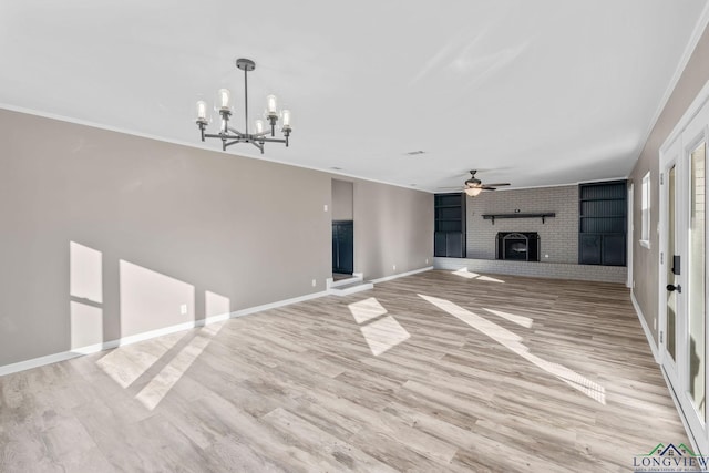 unfurnished living room with ceiling fan with notable chandelier, ornamental molding, light hardwood / wood-style floors, and a fireplace