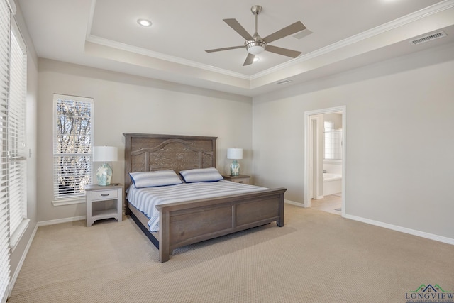 carpeted bedroom with ceiling fan, connected bathroom, a tray ceiling, and ornamental molding