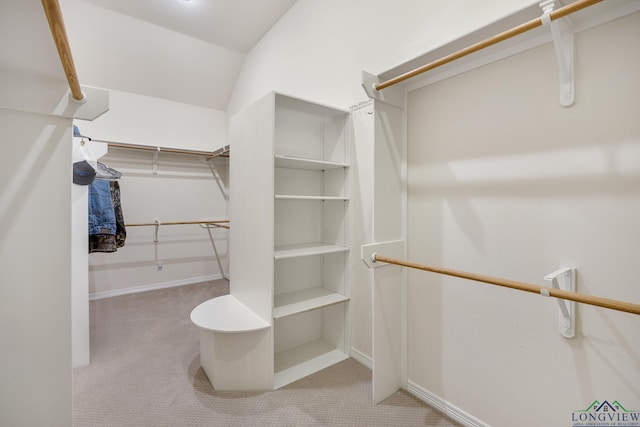 walk in closet featuring light carpet and vaulted ceiling