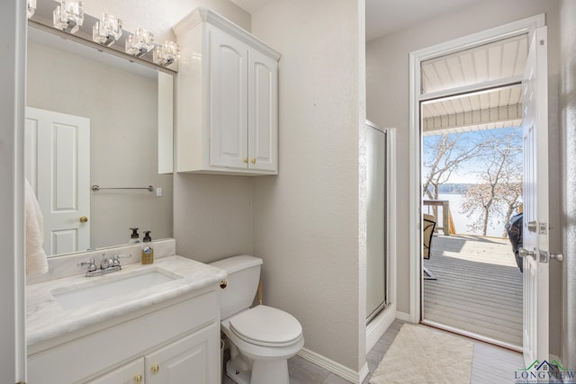 bathroom featuring vanity, toilet, and an enclosed shower