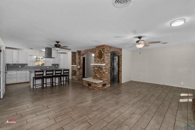 unfurnished living room featuring ceiling fan and a textured ceiling