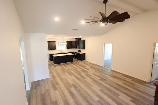 unfurnished living room featuring beamed ceiling, hardwood / wood-style floors, high vaulted ceiling, and ceiling fan