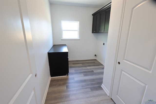 laundry area featuring cabinets, dark hardwood / wood-style flooring, and electric dryer hookup