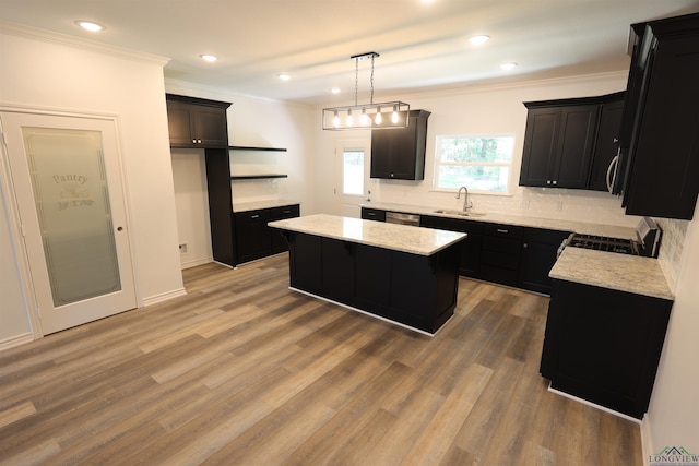 kitchen featuring sink, hanging light fixtures, hardwood / wood-style flooring, a kitchen island, and range