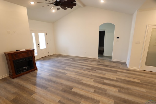 unfurnished living room featuring ceiling fan, dark hardwood / wood-style flooring, and lofted ceiling with beams