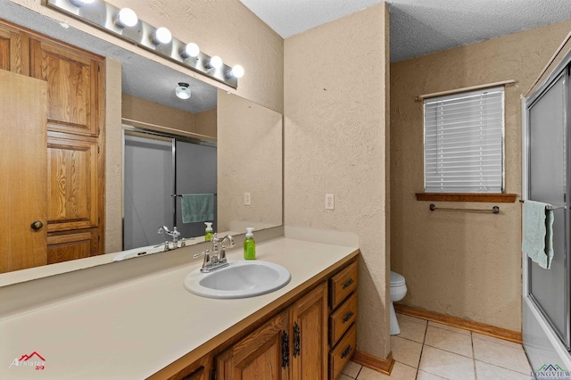 bathroom featuring tile patterned flooring, vanity, toilet, a shower with door, and a textured wall