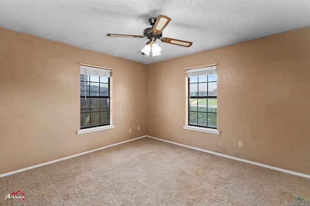 carpeted empty room with plenty of natural light, baseboards, a ceiling fan, and a textured ceiling