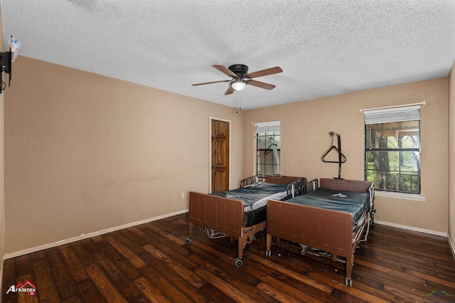 rec room featuring baseboards, a textured ceiling, wood finished floors, and a ceiling fan