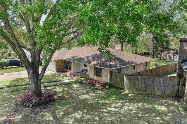 view of front facade featuring a chimney, fence, and brick siding