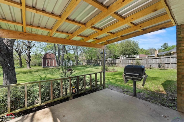 view of patio with fence, an outdoor structure, grilling area, and a shed
