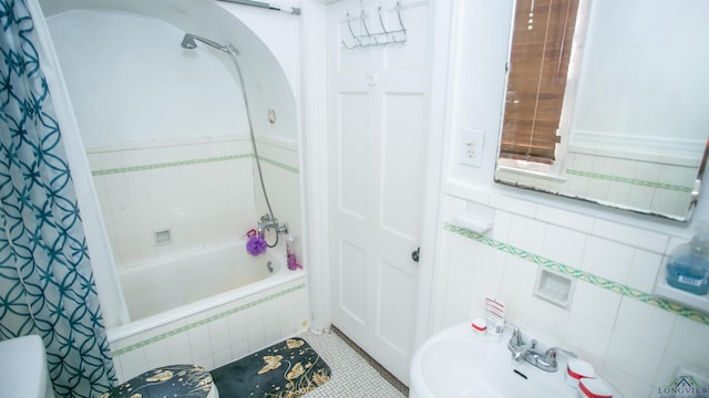 bathroom featuring tile patterned flooring, sink, tile walls, and shower / bath combination with curtain