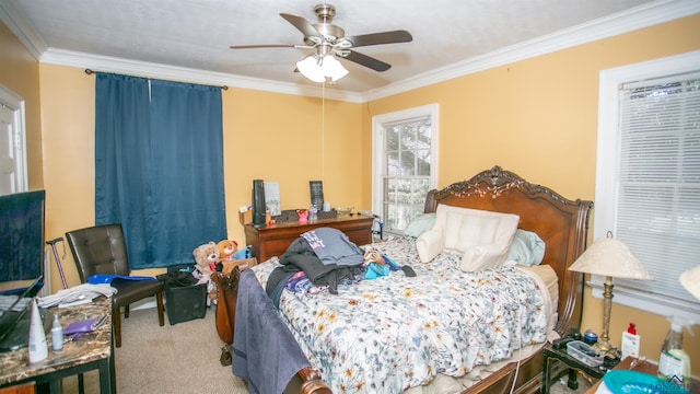 carpeted bedroom with ceiling fan and ornamental molding