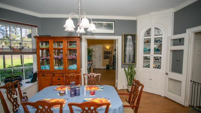 dining room featuring ornamental molding, an inviting chandelier, and wood-type flooring