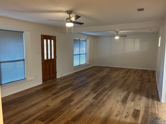 foyer with a textured ceiling, ceiling fan, and dark wood-type flooring