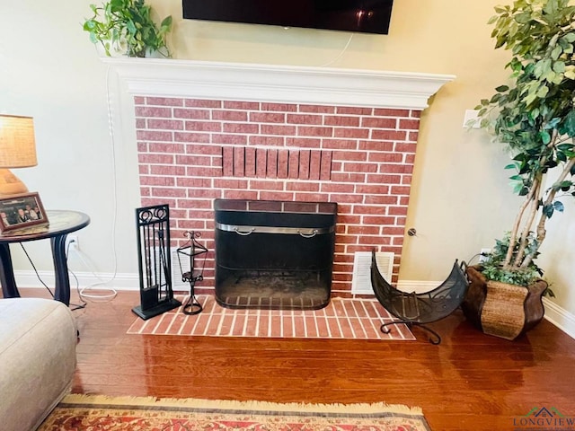 1928 Eastwood Dr, Henderson, TX 75652 - detailed view of wood finished floors, a fireplace, and baseboards