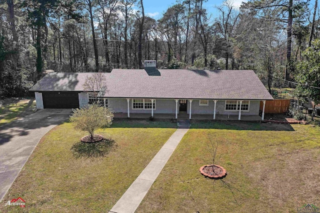 ranch-style house with a garage, roof with shingles, concrete driveway, and a front yard