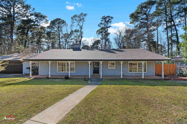 ranch-style home with brick siding, covered porch, fence, and a front yard