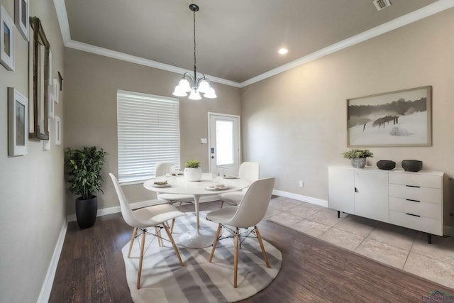 dining area with ornamental molding, a chandelier, baseboards, and wood finished floors