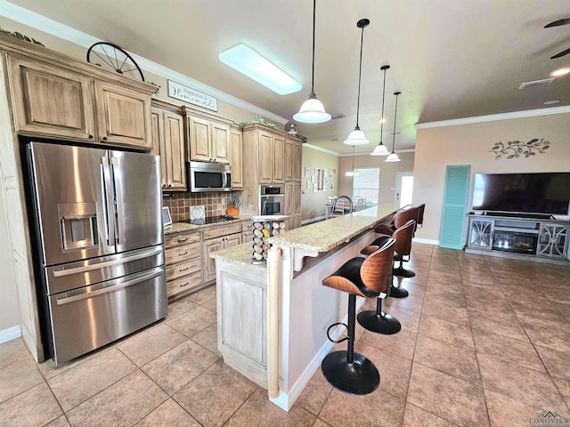 kitchen featuring light stone counters, crown molding, stainless steel appliances, tasteful backsplash, and a kitchen bar