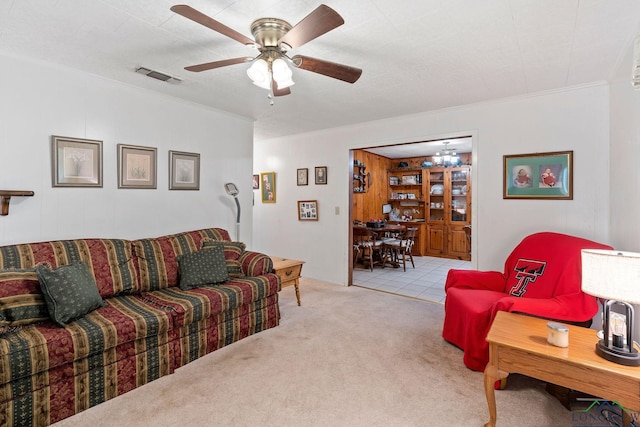 carpeted living room featuring ceiling fan and crown molding