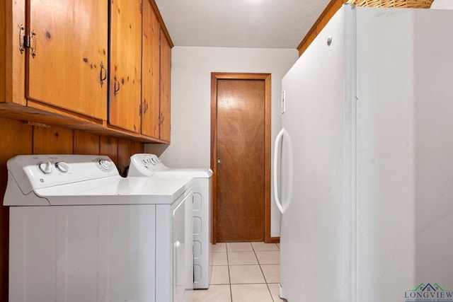 washroom with washer and dryer, cabinets, and light tile patterned flooring