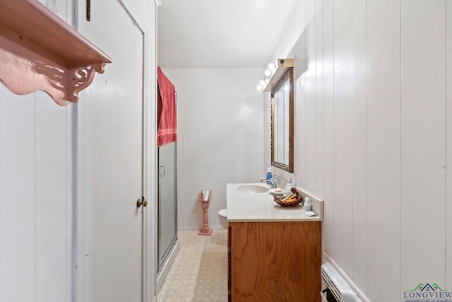 bathroom featuring vanity, toilet, ornamental molding, and walk in shower