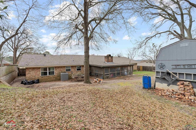 rear view of house with a sunroom, central AC, and a patio area