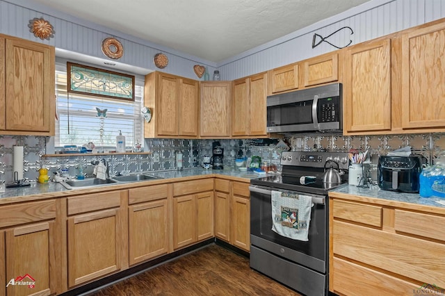 kitchen featuring appliances with stainless steel finishes, light brown cabinetry, sink, dark hardwood / wood-style flooring, and decorative backsplash