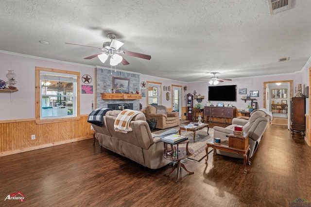 living room with crown molding, a fireplace, dark hardwood / wood-style flooring, and a textured ceiling