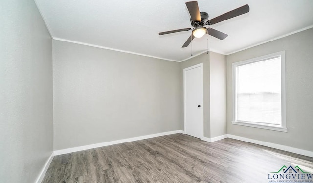 spare room featuring wood-type flooring, ceiling fan, and ornamental molding