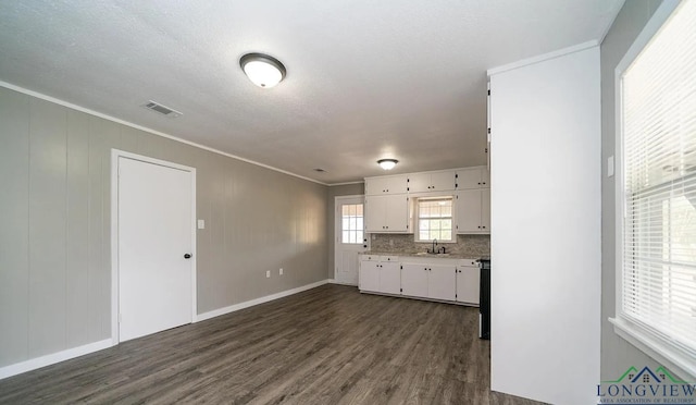 kitchen featuring white cabinets, sink, dark hardwood / wood-style floors, ornamental molding, and range