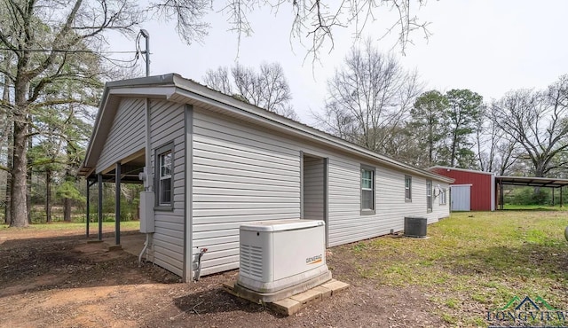 view of home's exterior featuring central AC unit and an outbuilding