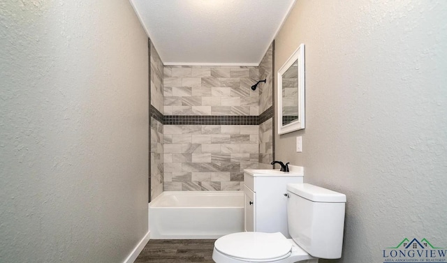 full bathroom featuring wood-type flooring, a textured ceiling, toilet, vanity, and tiled shower / bath