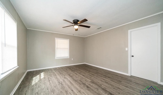 spare room with dark hardwood / wood-style floors, ceiling fan, ornamental molding, and a wealth of natural light