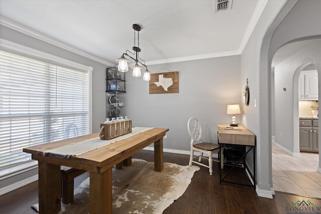 908 Victoria Dr, Longview, TX 75604 - dining area featuring arched walkways, ornamental molding, baseboards, and visible vents