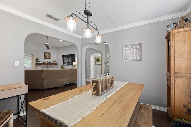 908 Victoria Dr, Longview, TX 75604 - dining room with crown molding, ceiling fan, arched walkways, dark wood-type flooring, and visible vents