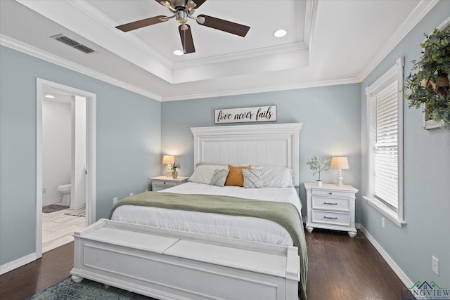 908 Victoria Dr, Longview, TX 75604 - bedroom with visible vents, baseboards, dark wood-type flooring, and a tray ceiling
