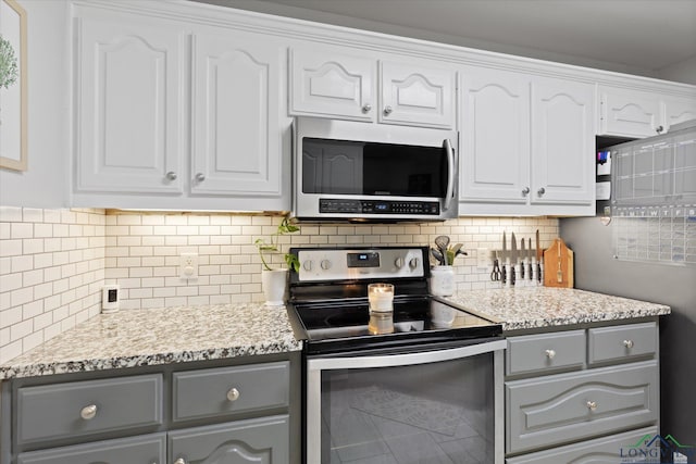 908 Victoria Dr, Longview, TX 75604 - kitchen featuring decorative backsplash, gray cabinets, stainless steel appliances, and white cabinets