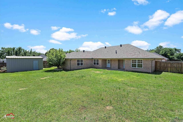 rear view of property featuring a storage unit, a fenced backyard, an outdoor structure, and a yard
