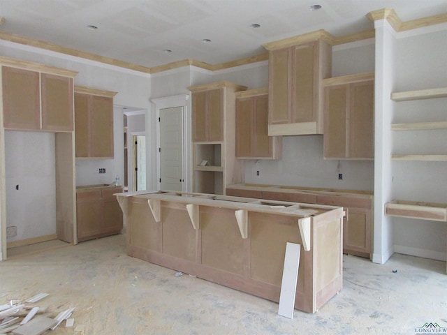 kitchen featuring light brown cabinets, a kitchen island, and ornamental molding