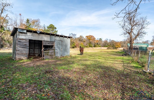 view of yard featuring a rural view and an outbuilding