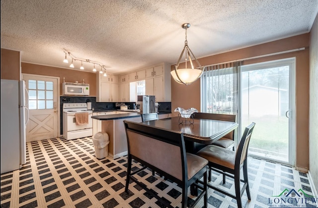 kitchen with a kitchen breakfast bar, backsplash, pendant lighting, white appliances, and white cabinets