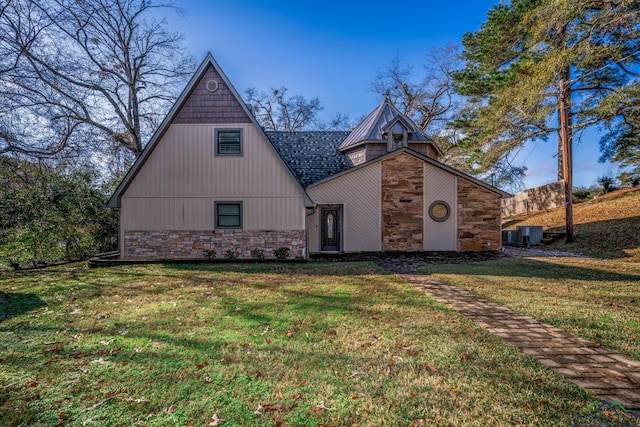 view of front of property featuring a front yard and central AC