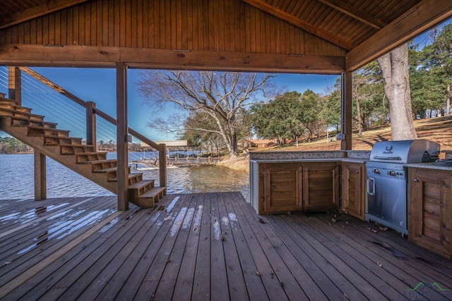 deck featuring an outdoor kitchen, a water view, and area for grilling