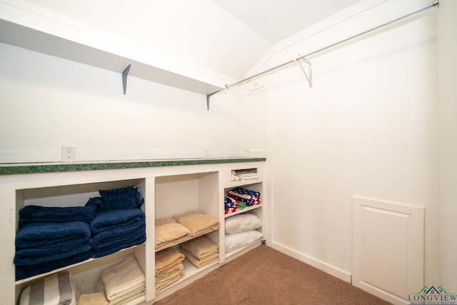 walk in closet featuring carpet flooring and lofted ceiling