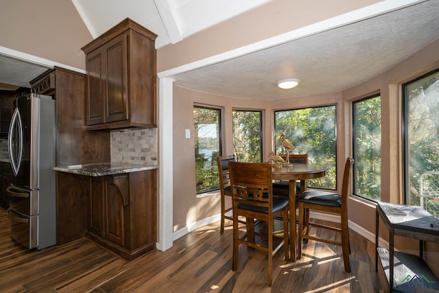 dining area featuring a textured ceiling, dark hardwood / wood-style floors, and a skylight